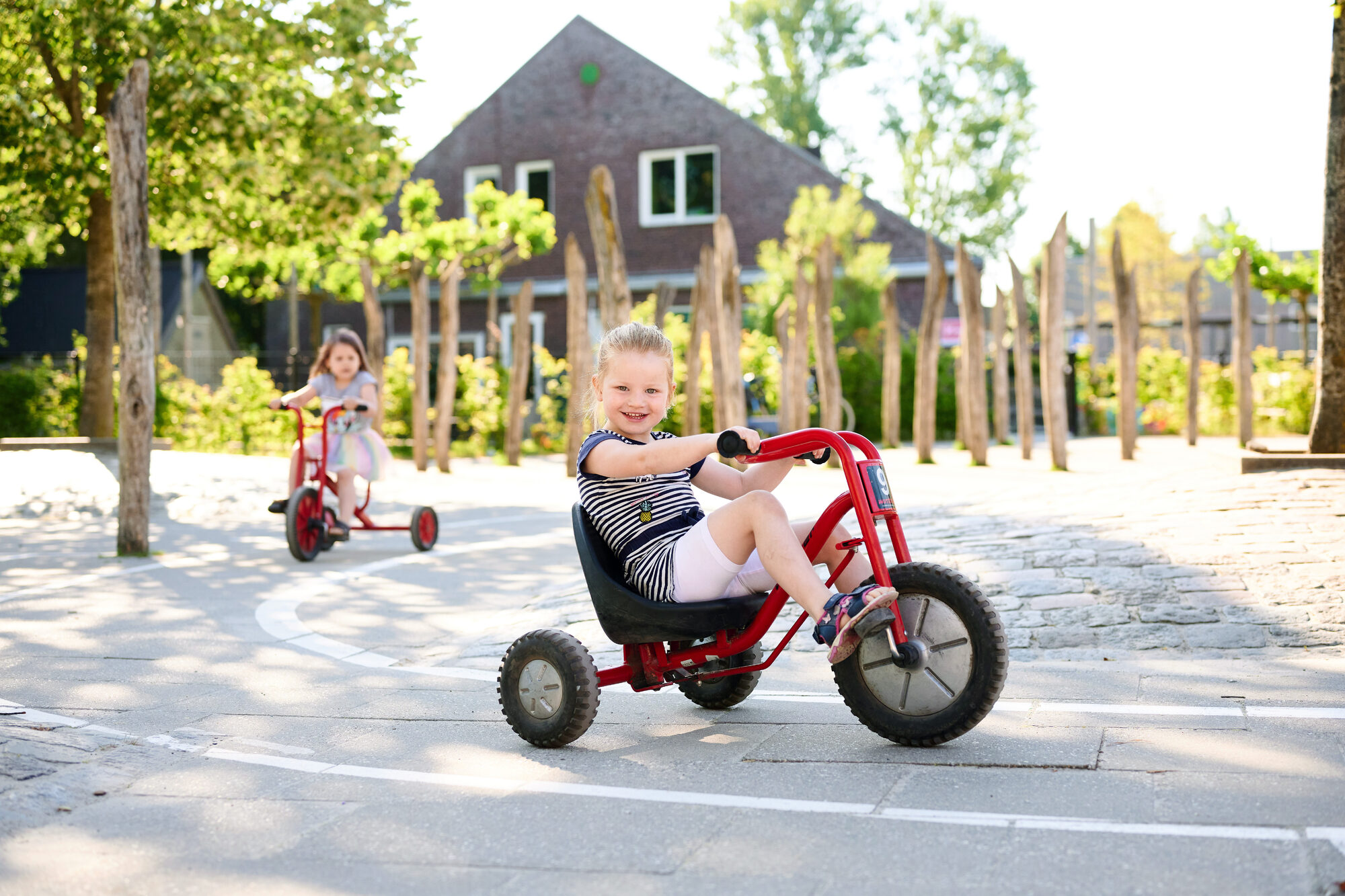 Meisje op driewieler het Karrepad
